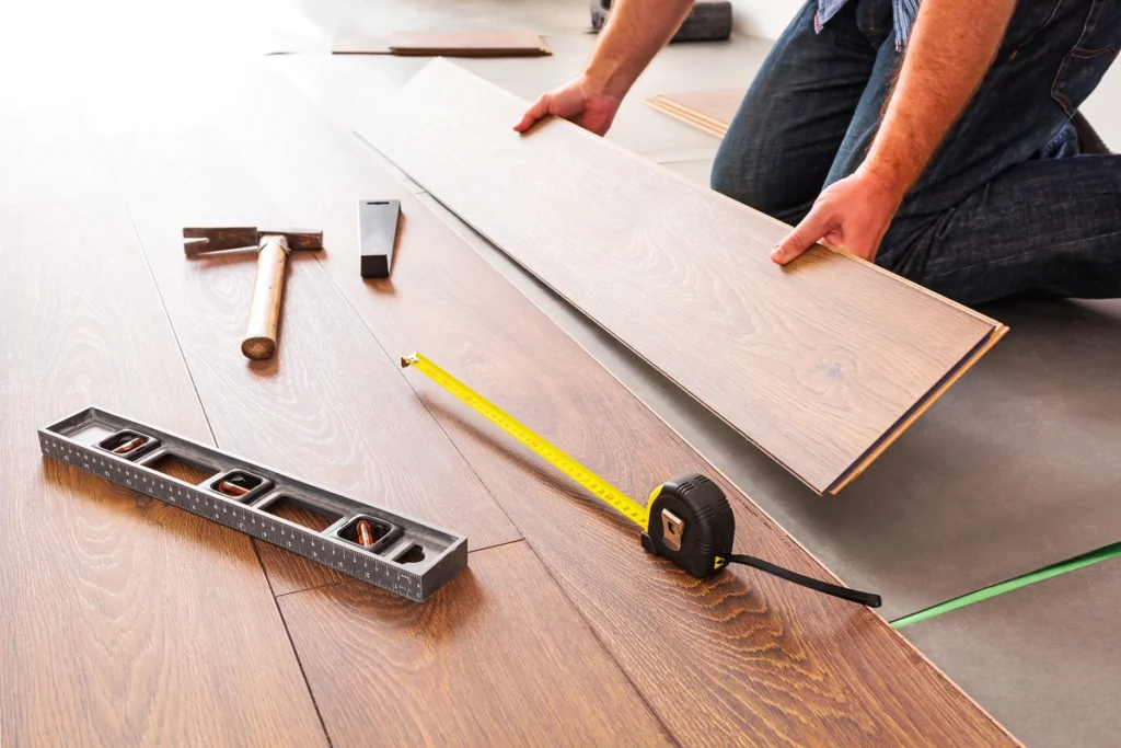 man installing new wood flooring panels